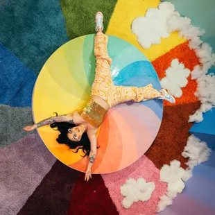 a woman laying on a rainbow wheel
