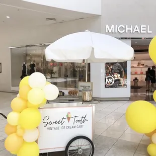 ice cream cart with yellow balloons