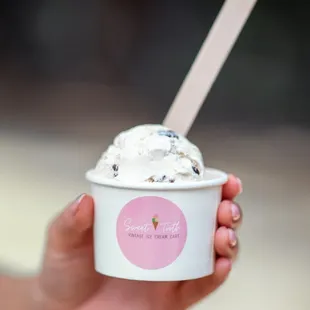 a hand holding a cup of ice cream