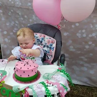 a baby in a highchair eating a watermelon cake