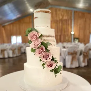 a wedding cake decorated with pink roses