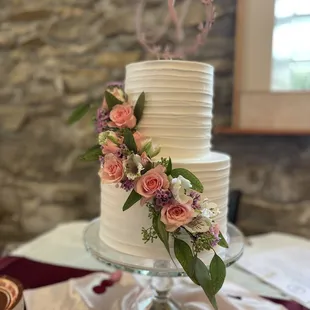 a white wedding cake with fresh flowers