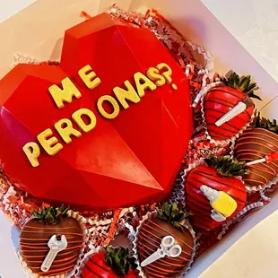 a heart shaped cake with chocolate covered strawberries