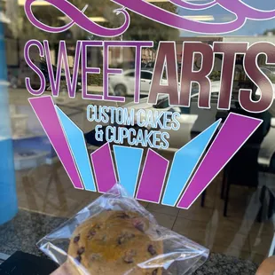 a hand holding a chocolate chip cookie