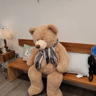 a large teddy bear sitting on a bench