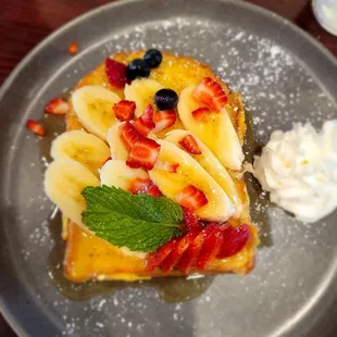 French Toast with honey, bananas, strawberries, blueberries and fresh whipped cream.