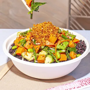 a bowl of food with chopsticks