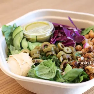 Hummus Crunch Salad - Hummus, olives, chickpeas, tomatoes, cucumbers, cabbage, red onions, basil, za'atar breadcrumbs, pesto vinaigrette