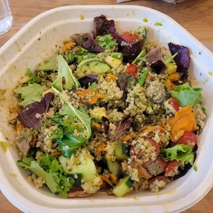 Make-your-own bowl, with garlic steak, warm quinoa, salad, sweet potato, tomato, apple, cucumber, and pesto sauce.