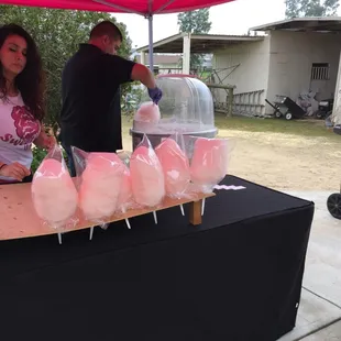 a man and a woman standing under a pink tent