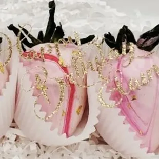 a box of pink and gold decorated cookies