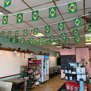 the inside of a restaurant with flags hanging from the ceiling