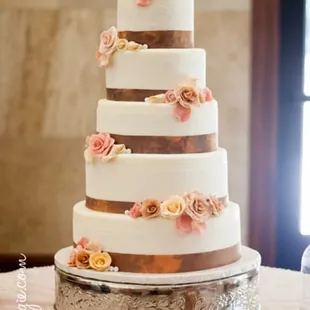 Ivory fondant. Brown/copper ribbon and ivory lace. Scattered pearls near each rose cluster. Simply amazing work!
