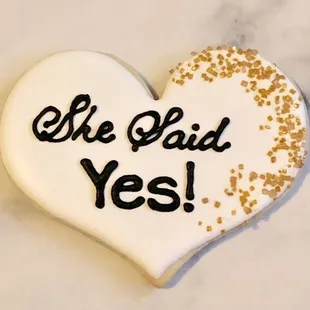 a heart shaped cookie with the words she did yes