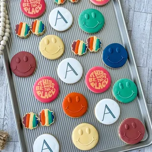 a tray of cookies with letters and smiley faces