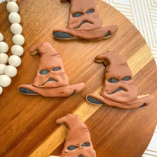 a wooden board with cookies decorated like witches hats