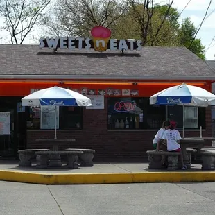 a man sitting on a bench under umbrellas
