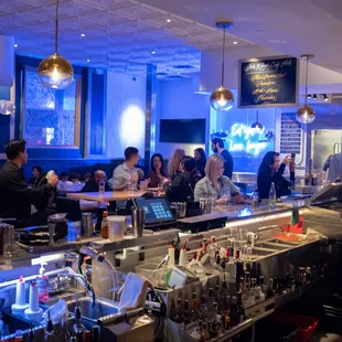 a crowd of people sitting at the bar