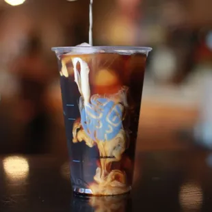 a cup of iced coffee with a sprinkle of whipped cream