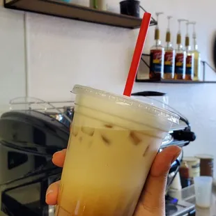 a hand holding a cup of iced coffee