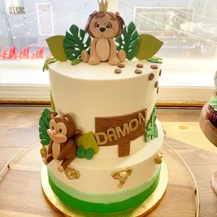 a three tiered cake with a monkey topper