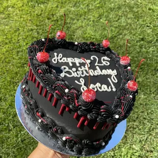 a hand holding a birthday cake