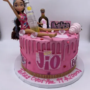 a barbie doll sitting on top of a birthday cake