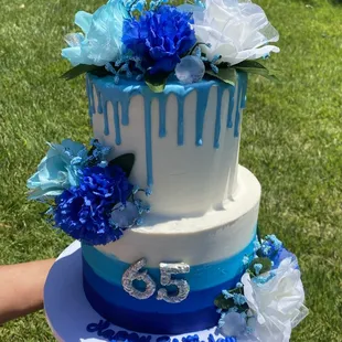 a birthday cake decorated with blue and white flowers