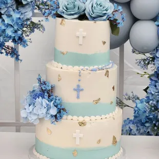 a three tiered cake with blue flowers