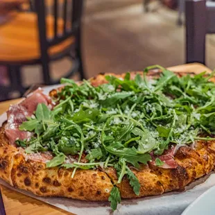 a pizza with arugula and cheese