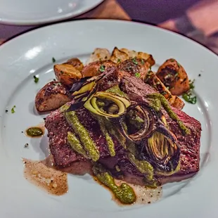 a steak and vegetables on a white plate