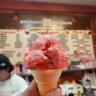 Strawberry ice cream in front of menu inside
