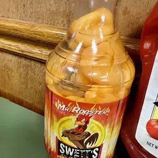 a jar of sweet potato chips next to a bottle of hot sauce