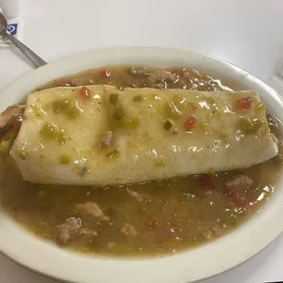 Breakfast burrito with bacon and smothered in green chile