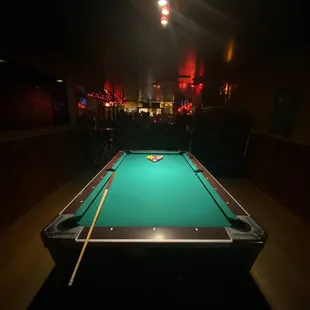 a pool table in a dimly lit room