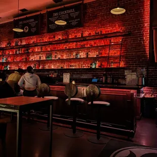 a man sitting at a bar in front of a brick wall