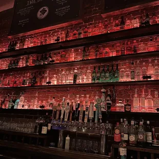 a wall of liquor bottles in a bar