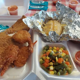 Catfish, breaded shrimp, baked potato and mixed vegetables.