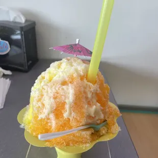 a yellow cup with a straw and a pink umbrella