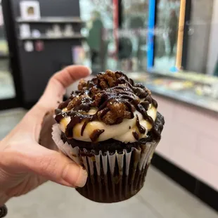 a hand holding a cupcake