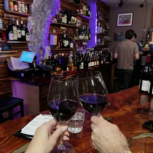 two people clinking wine glasses