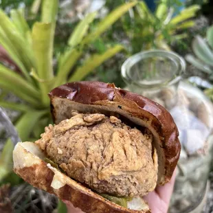 a hand holding a sandwich