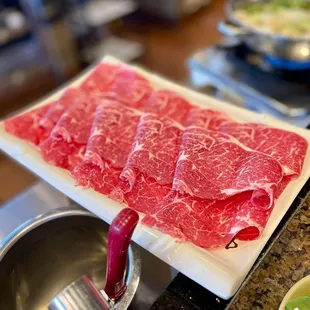 a plate of raw meat on a stove