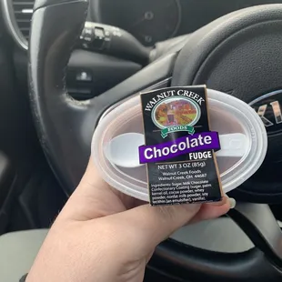 a hand holding a cup of chocolate