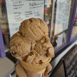 a hand holding a cone of ice cream
