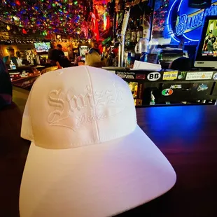 a white hat with swizzle on it