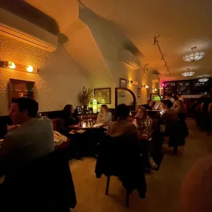 people sitting at tables in a dimly lit restaurant