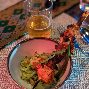 a bowl of food and a glass of beer