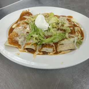 Enchilada supreme, a delicious corn tortilla, one with cheese, one beef, one shredded chicken, and one beans top it with our enchilad sauce