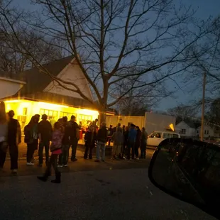 a crowd of people standing outside of a house